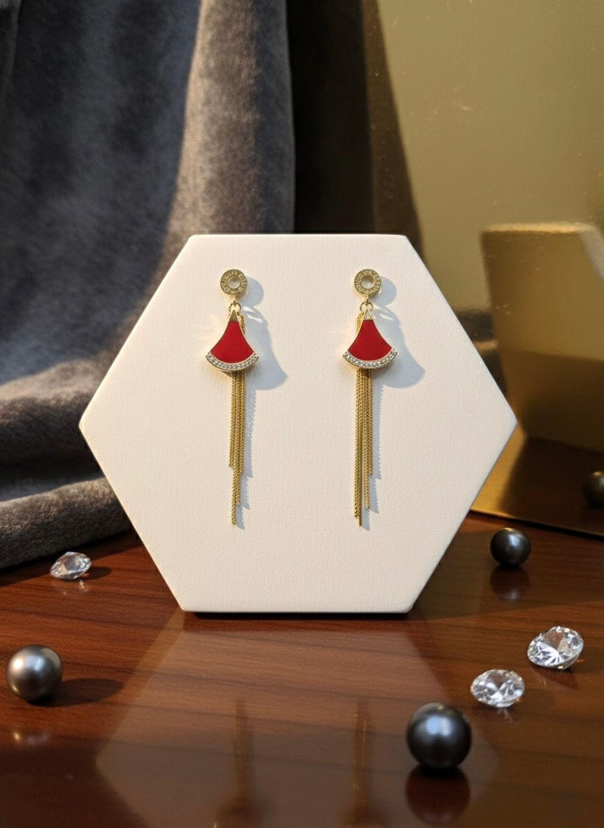 Red earrings on display, gold chains, white stand, Lavish Jewellery.