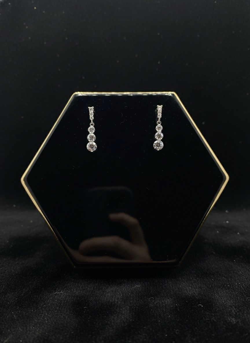 Elegant drop earrings with three stones, presented on a black display stand, Lavish Jewellery.