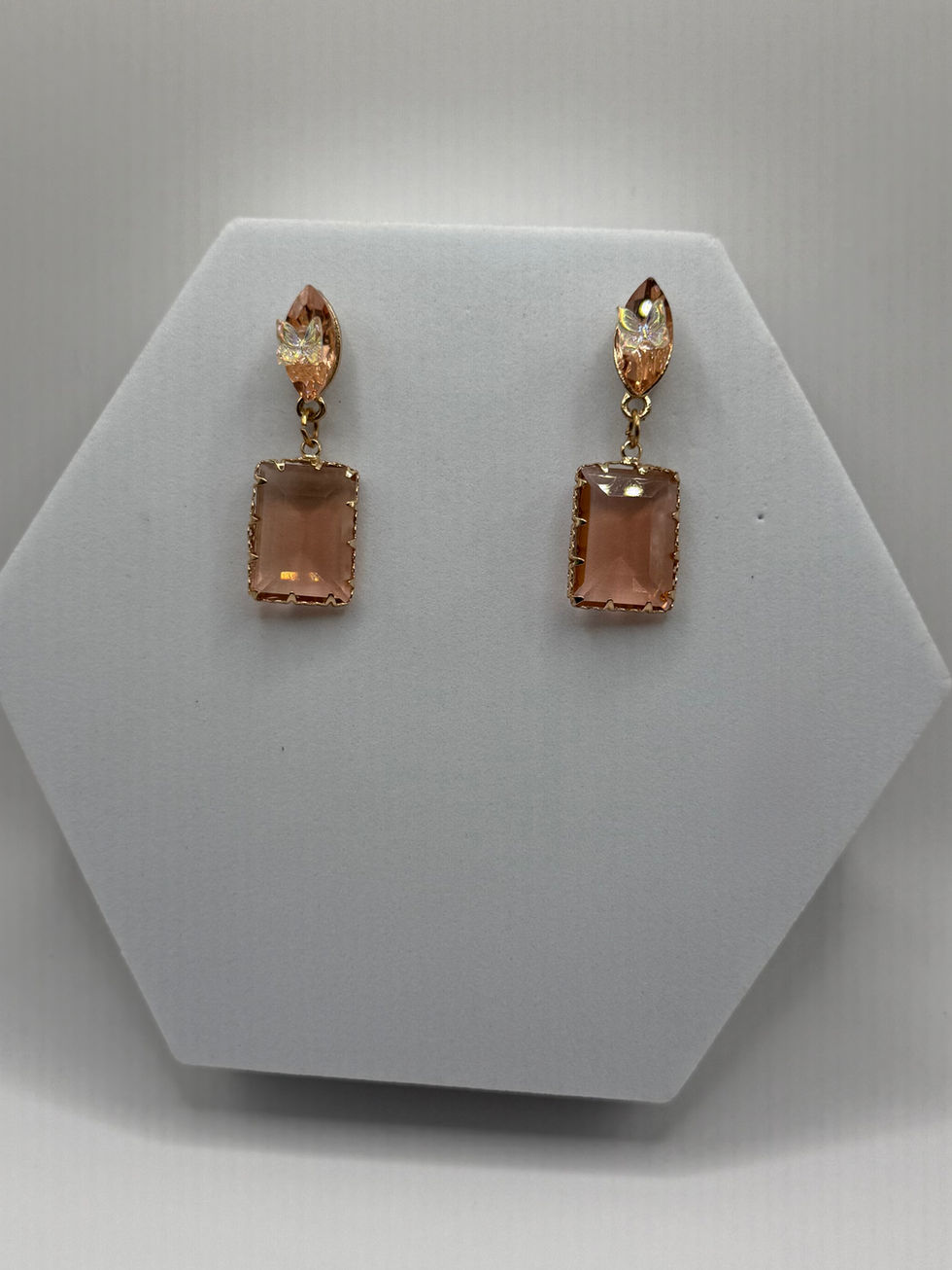 Elegant golden earrings with square gems displayed on white stand Lavish Jewellery