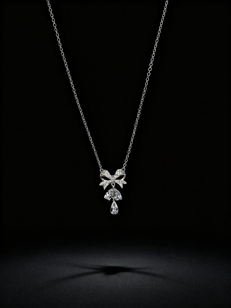 Pearl Ribbon Pendant Necklace on black background, Lavish Jewellery.