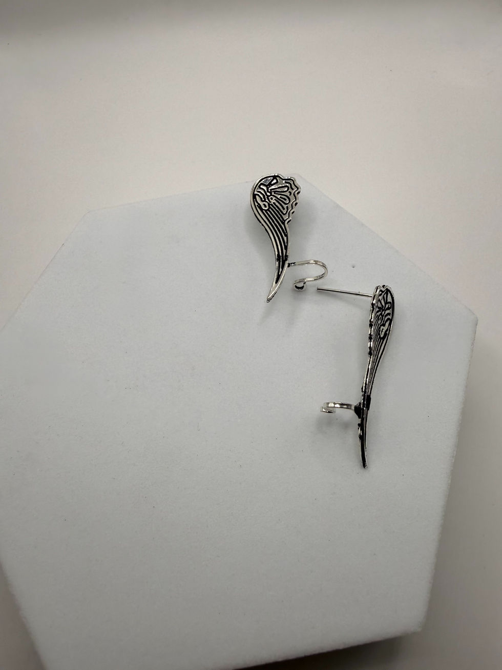 Dangling silver earrings with intricate design displayed against a white background. Lavish Jewellery