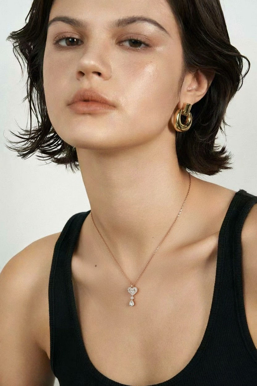 Woman wearing gold earrings and a diamond pendant necklace. Lavish Jewellery