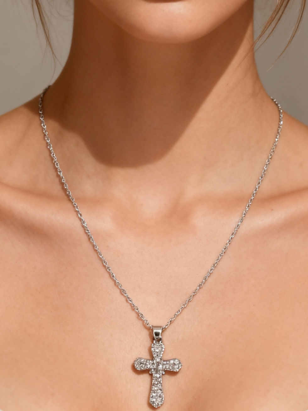 A woman wearing a silver cross pendant necklace, Lavish Jewellery.