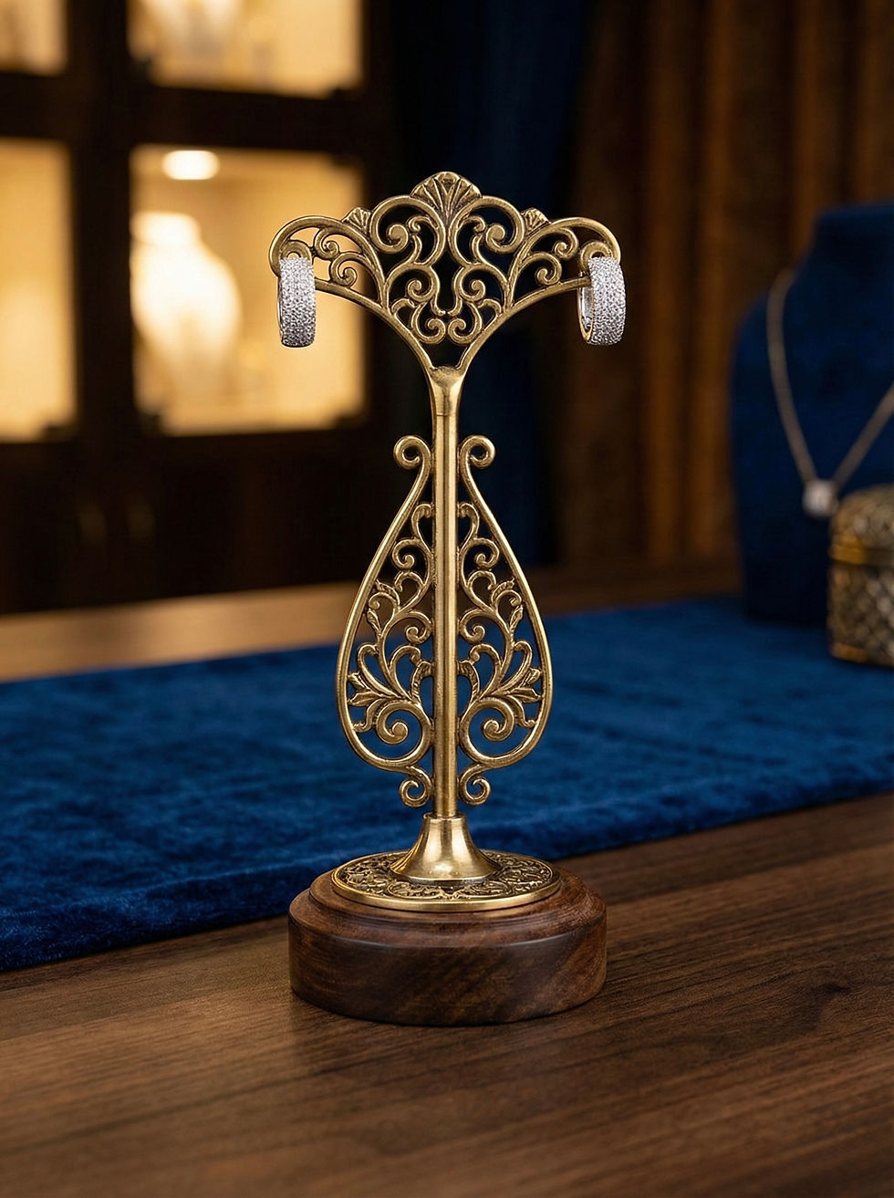 Ornate earring display with silver earrings on display in front of blue cloth.