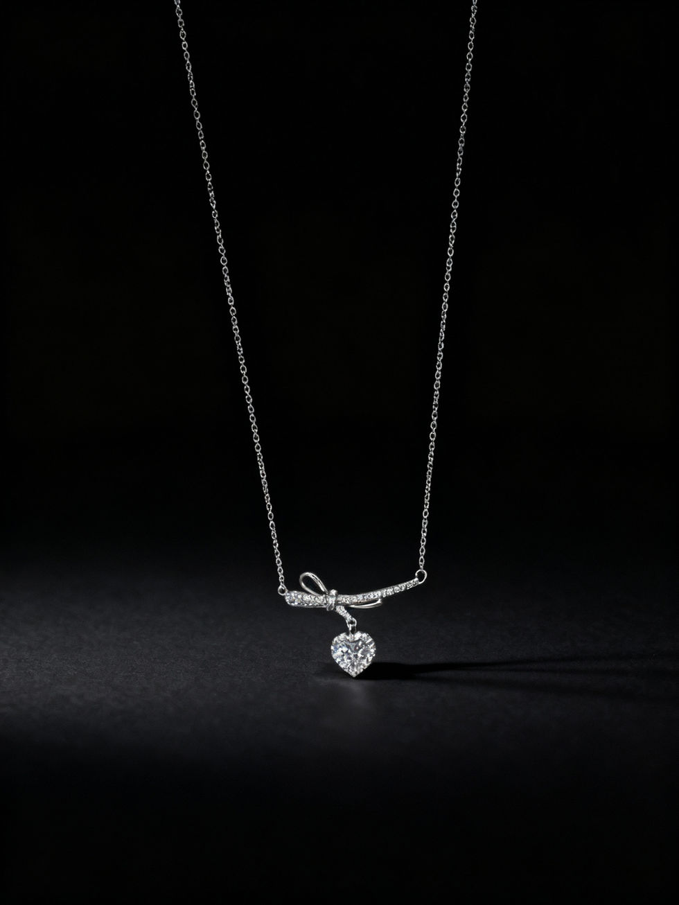Elegant silver necklace with heart pendant against a dark background Lavish Jewellery