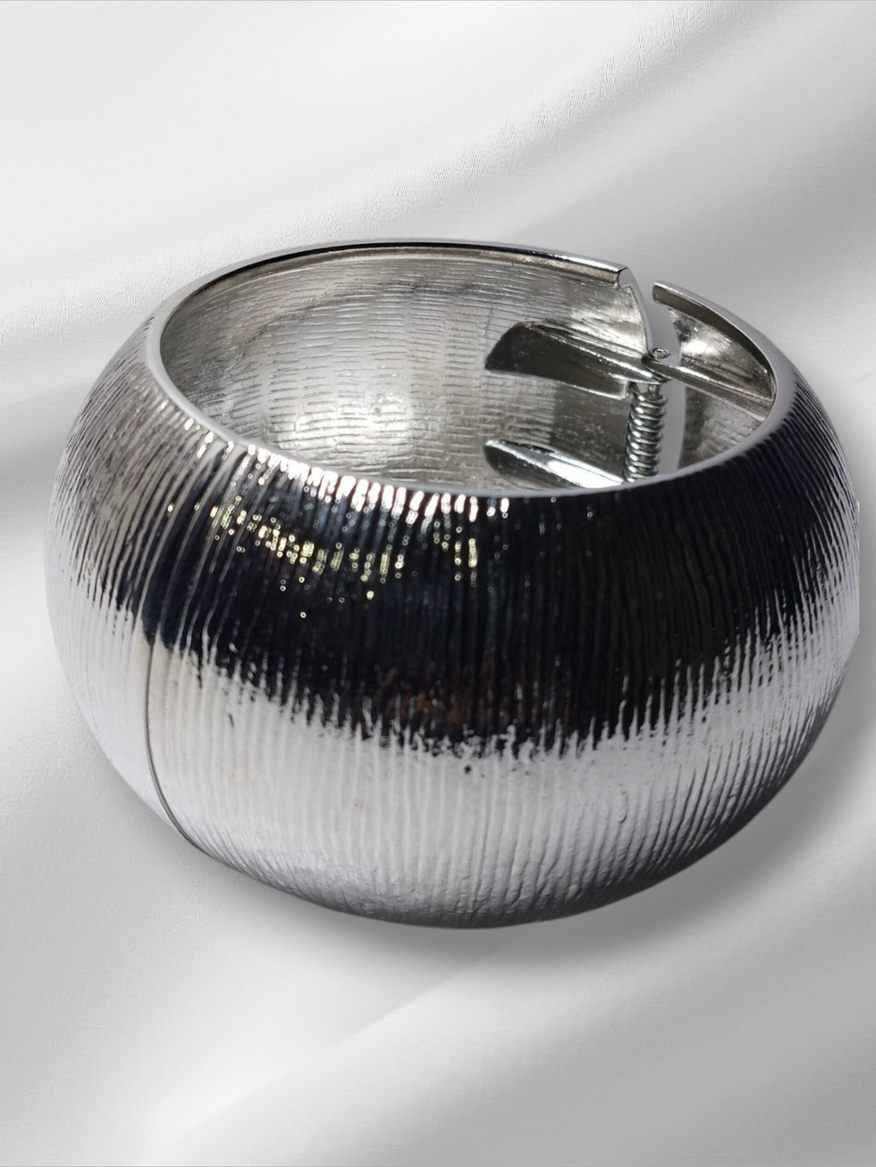 Silver metal bracelet, textured design, close-up shot on blurred background, Lavish Jewellery.