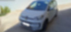 Fehér Volkswagen Up parkol a vízparton.