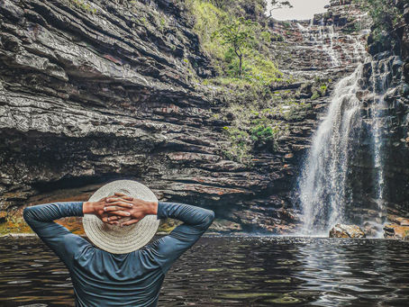 um cliente posando para a foto em uma cachoeira