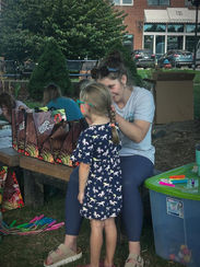 child getting face painted at outreach event