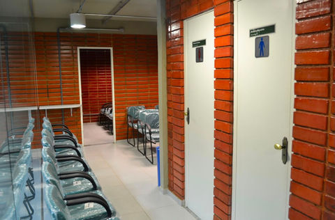 Corredor com cadeiras de espera e portas de sanitários.