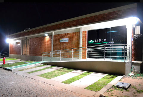 Fachada da Lider com rampa de acessibilidade iluminada à noite.