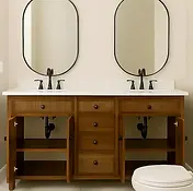 Modern double vanity, oval mirrors, wooden cabinets, white countertop. Home improvement.