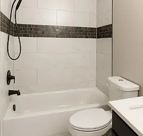 "Modern bathroom remodel in Conyers, GA, featuring a white subway tile shower with dark accent trim and new fixtures by Wesley’s Workers."