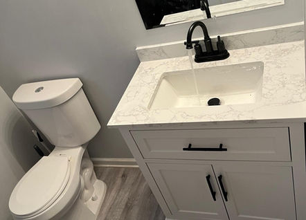 Freshly renovated bathroom featuring a new white vanity, sink, and grey flooring in a Lawrenceville, GA home."