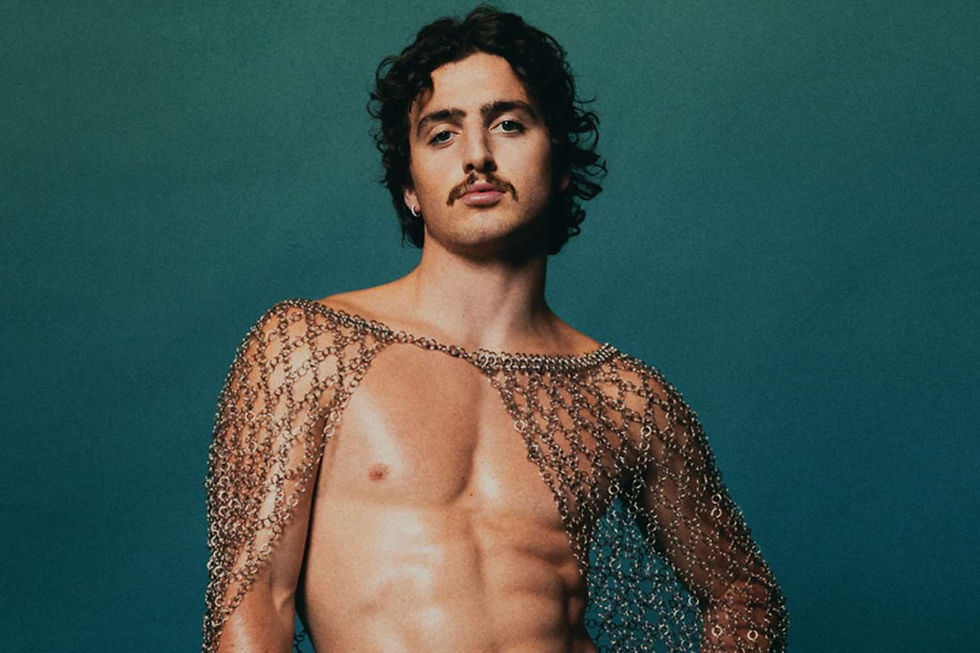 Benson Boone posing shirtless in a metallic chainmail top for Rolling Stone