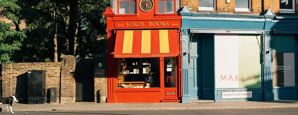 A vibrant red and yellow-fronted bookshop with a neighbouring storefront, highlighting the potential of investing in commercial properties. Ideal for investors seeking long-term capital appreciation and rental income through commercial spaces with Roberts Renovations.