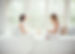 A reiki practitioner and a client engaged in a compassionate conversation about grief in a calm, comforting space.