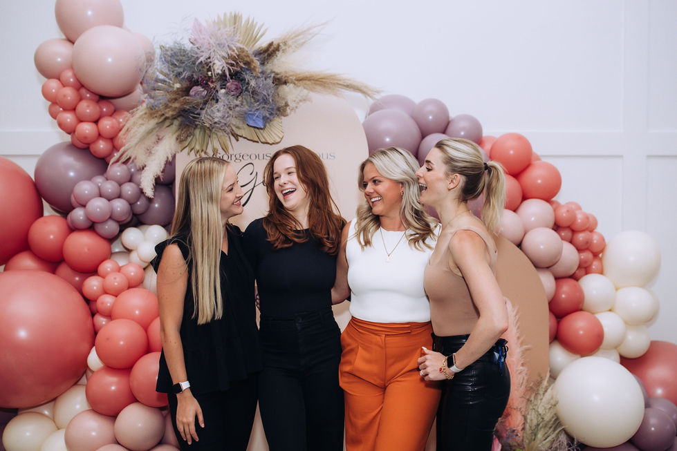 Honey at Hutton House - group photo near backdrop and balloon installation