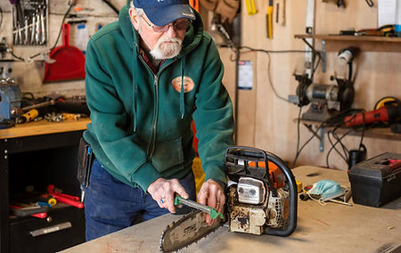 Mechanic sharpening a chainsaw.