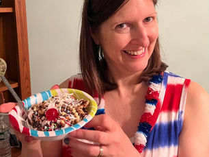 A woman holding a paper bowl with an ice cream sundae inside.