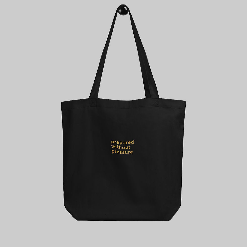 Front view of black organic cotton tote with embroidery "prepared without pressure" on front