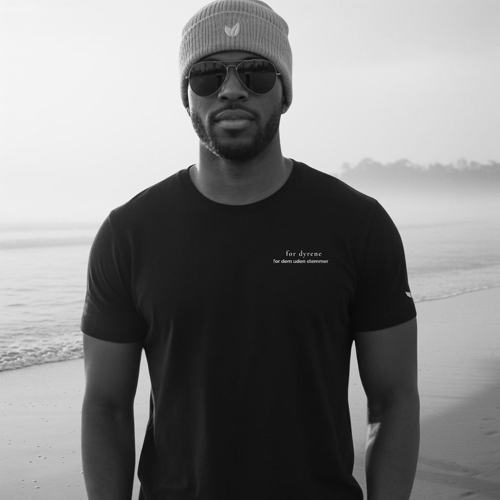 Man wearing black eco tee with left-chest Danish print, outdoors