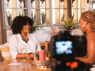 Dawn Faith sitting on the set of her talk show Deep & Meaningful, surrounded by cozy, neutral-toned furniture she personally selected to create a home-like atmosphere.