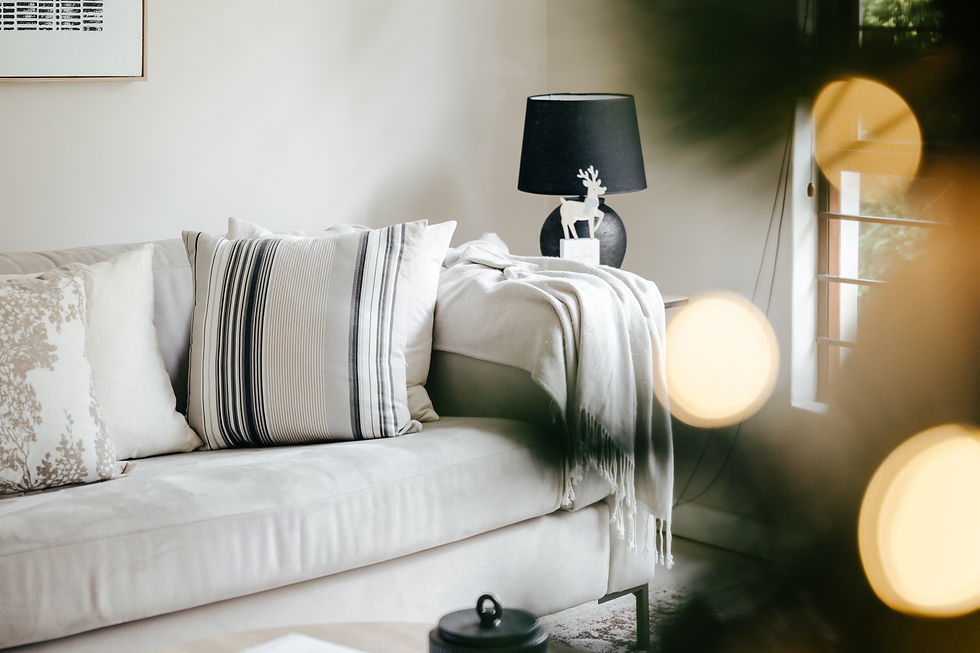 Wooden deer ornament on a Christmas tree, surrounded by warm lights and green pine branches. Cozy holiday atmosphere.