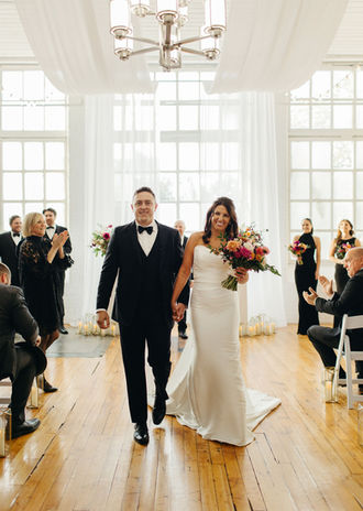 Couple walking out of their wedding ceremony happily married! Photo by Christina Rosario.