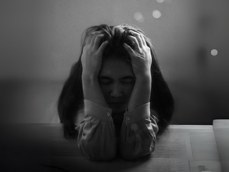 A photo of a woman with her head in her hands
