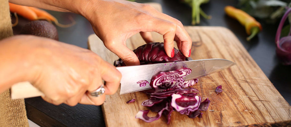 Midlife woman preparing a healthy meal in a bright kitchen to support energy and hormone health.