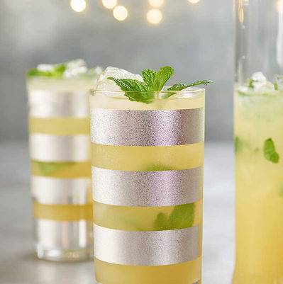 Lemonade with mint served in tall glasses with silver stripes, styled on a light background