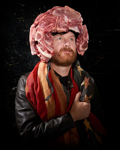 Man wearing a helmet made of raw meat with a scarf