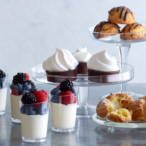 Elegant assortment of panna cotta, cupcakes, and pastries on tiered stands