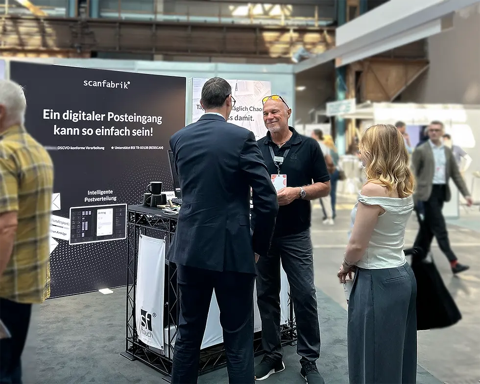 Messestand der Scanfabrik auf der Messe KOMMUNAL – Gespräch zwischen Vertriebsteam und interessierten Besucherinnen und Besuchern.