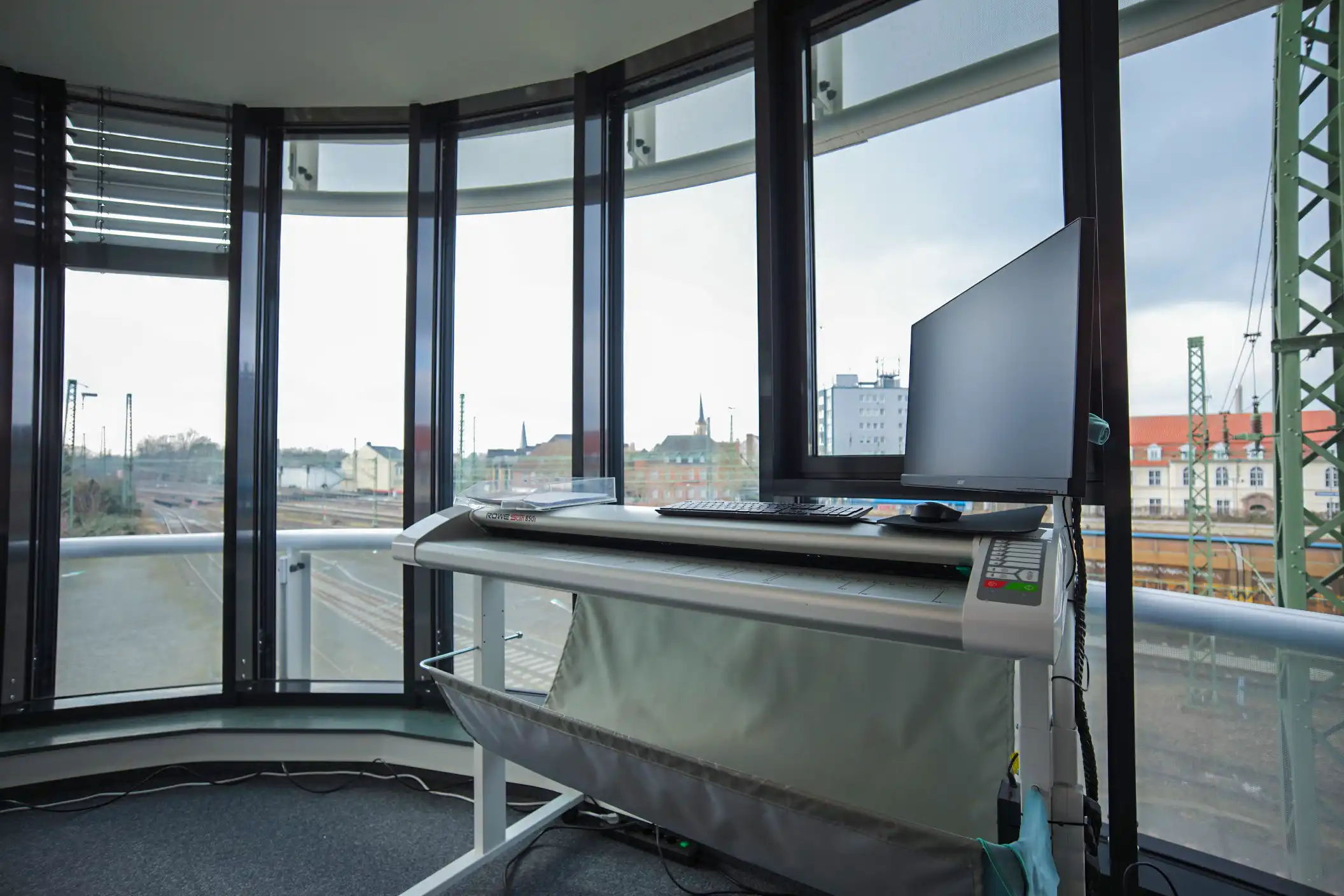 Arbeitsplatz mit Scanner und Blick auf den Bahnhof Gütersloh – Standort der Scanfabrik Scanservices