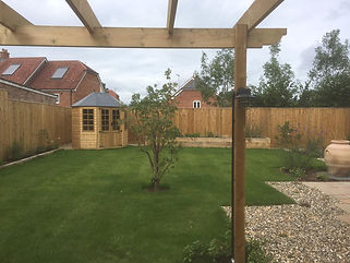 Our landscaping services are a great way to creat functional outdoor space, as seen in this example, with lawn and patio space, as well as fencing and oal planters.