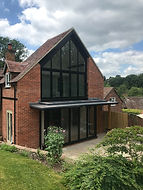 Modern glazed gable end extension. lets in natural light and allows for views of the stunning surroundings. Maintains the traditional look of the building. Finished with aluminium bifold doors and a one piece glass balcony.