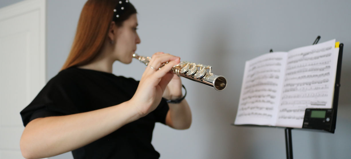 Natalina Scarsellone playing flute facing away from the camera