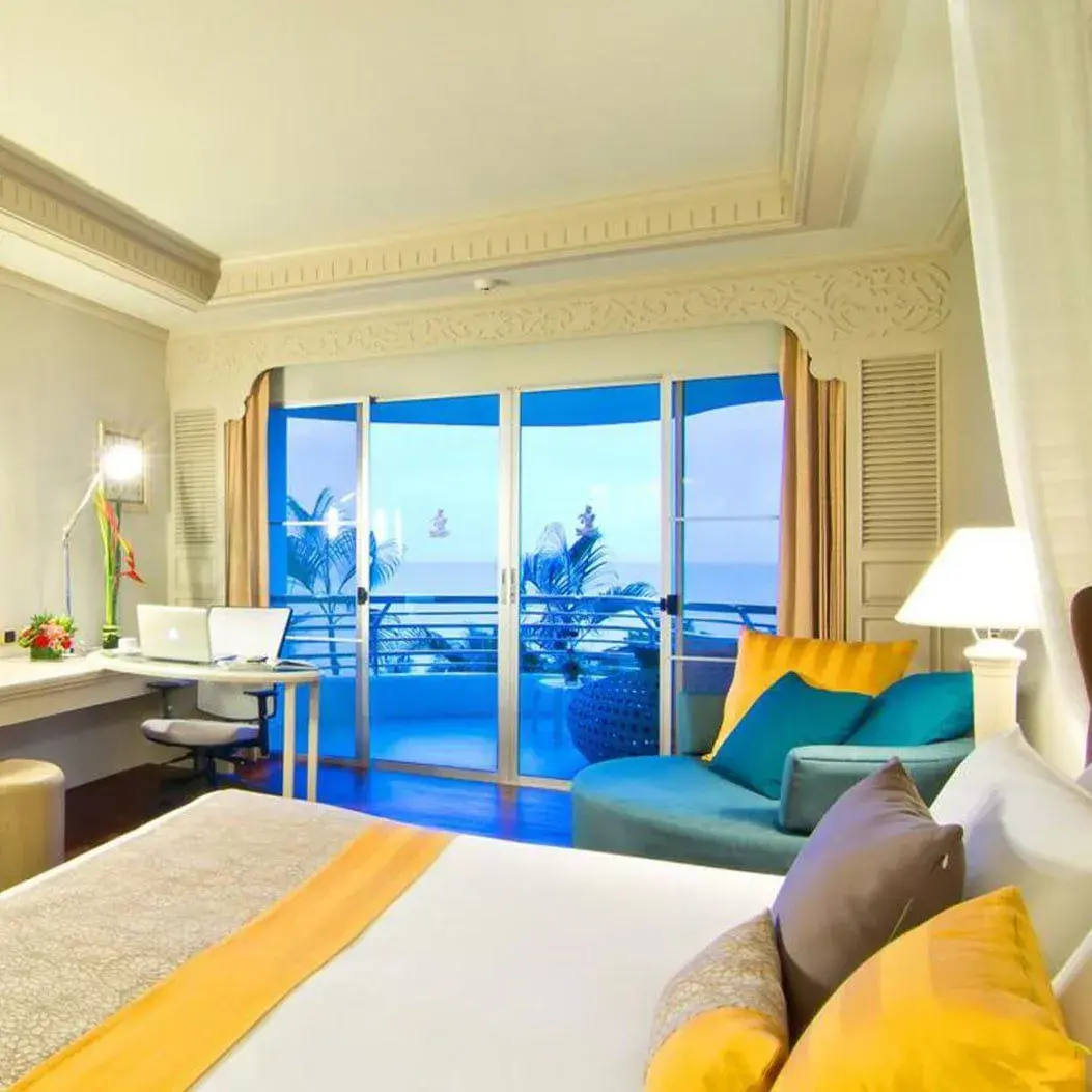 Просторный номер с панорамными окнами, современным дизайном и видом на море сквозь пальмы