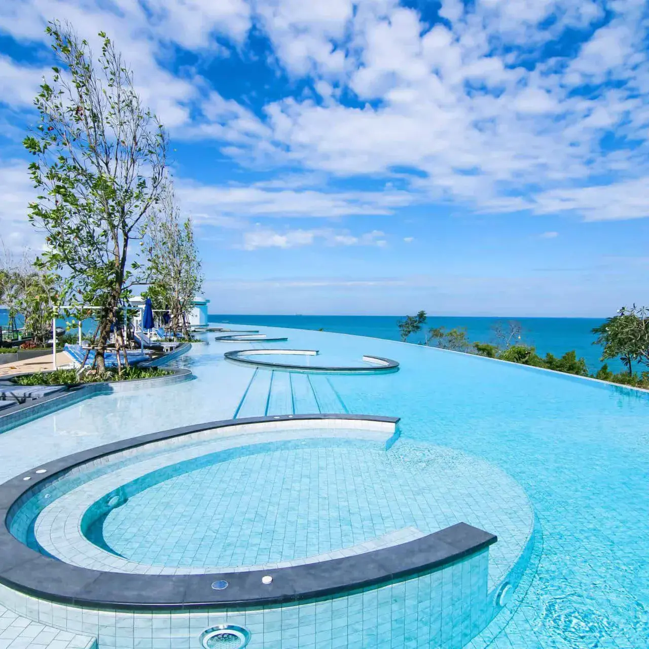 Изогнутый инфинити-бассейн отеля ROYAL CLIFF GRAND с панорамным видом на Сиамский залив