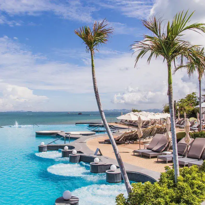 Элегантная зона отдыха у бассейна с каскадными фонтанами, шезлонгами и видом на море