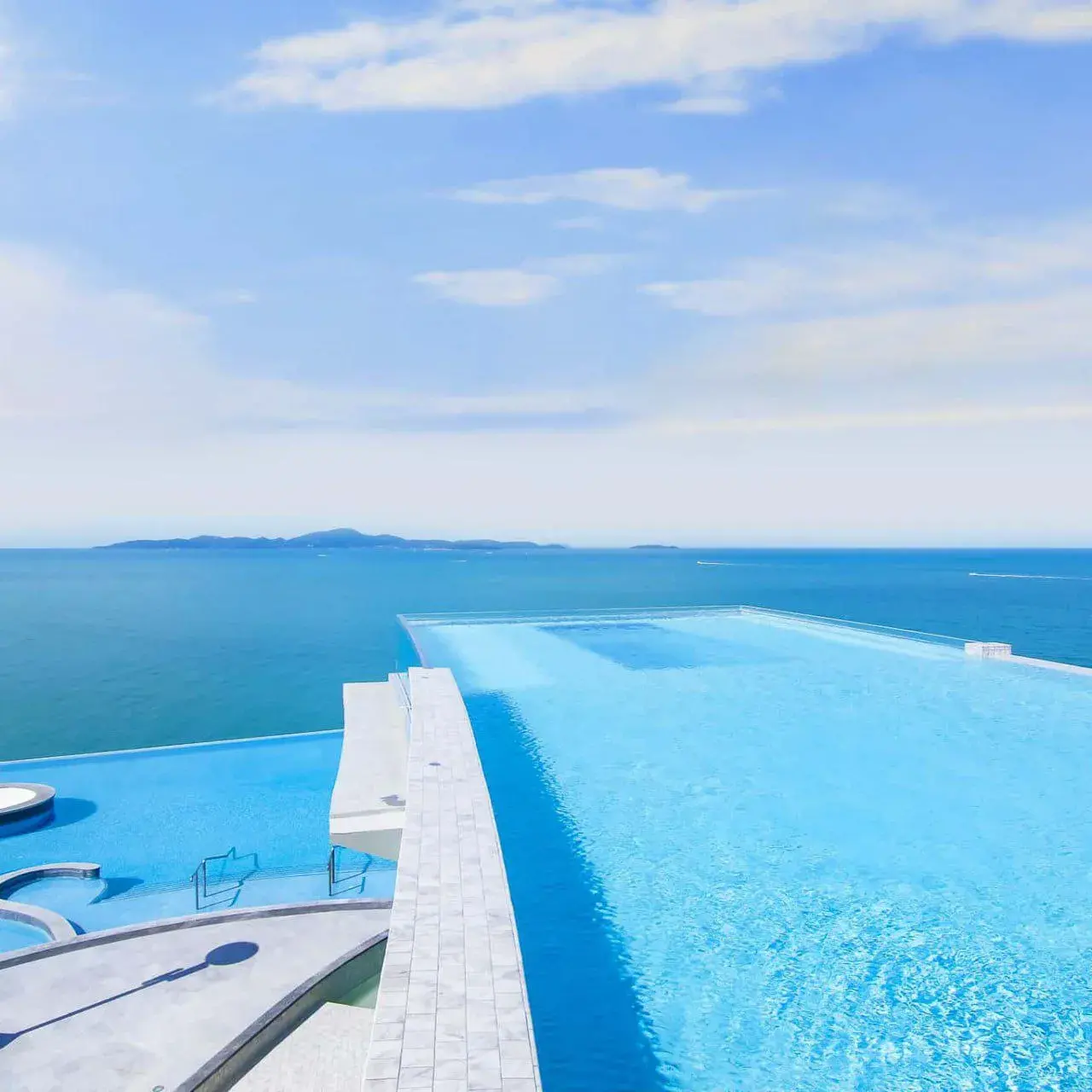 Главный инфинити-бассейн отеля с белоснежной кромкой сливается с горизонтом Сиамского залива