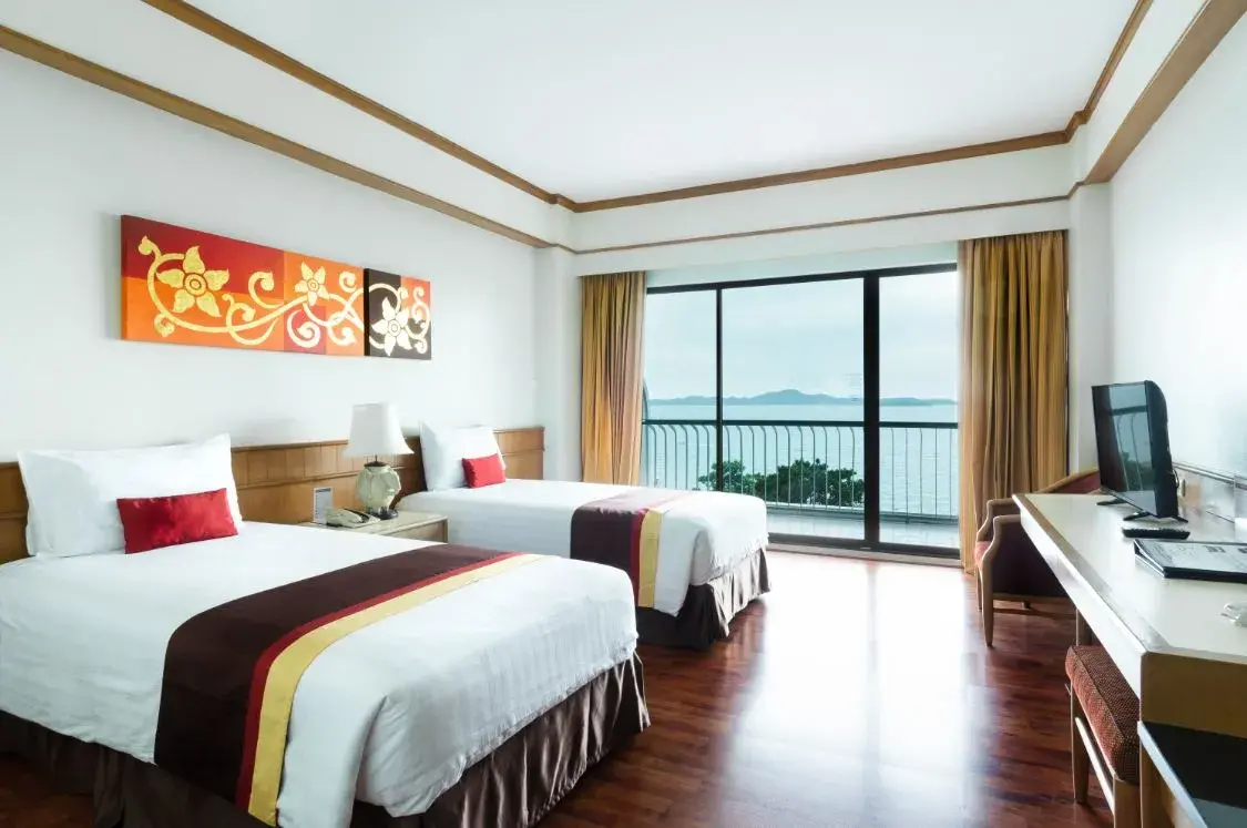 Просторный люкс в Cosy Beach Hotel с гостиной зоной, большим диваном, LCD телевизором и двуспальной кроватью с декоративным изголовьем. Интерьер в теплых тонах с деревянными элементами отделки