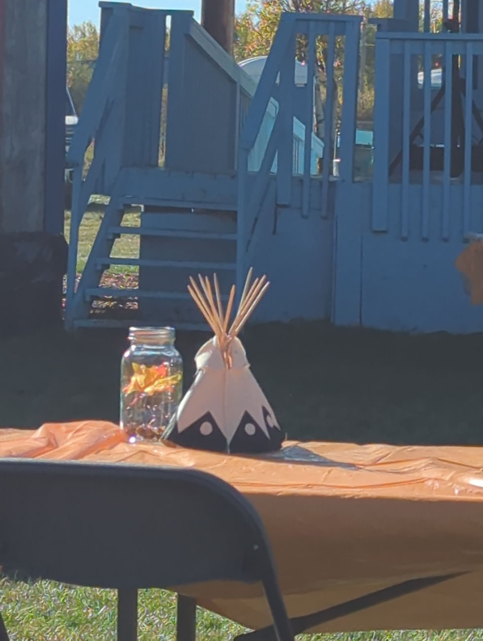 Close-up view of a shared meal table at an outdoor community gathering.