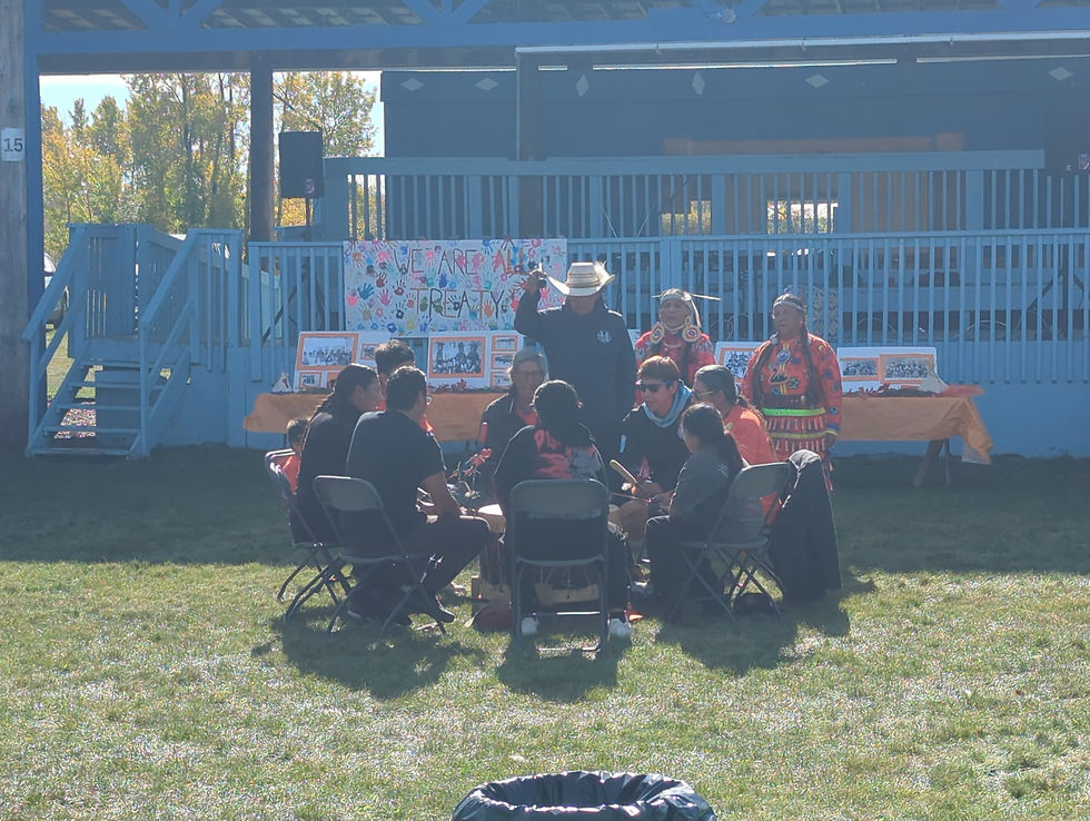 Low-angle view of women jingle dancers moving at an outdoor community gathering.