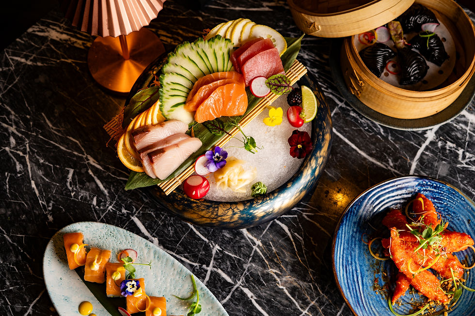 A beautifully arranged selection of sashimi, sushi rolls, and dim sum presented on elegant tableware, showcasing the artistry and diversity of Minoa food.