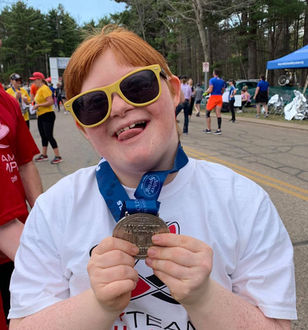 Child with disabilities shows off her race day metal. 