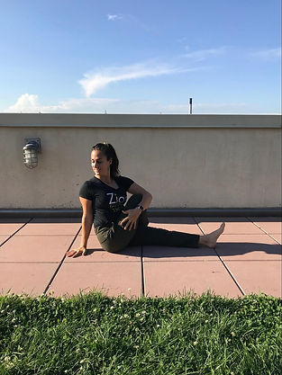 therapist with Zion Physical Therapy t-shirt demonstrating the straight leg twist yoga pose