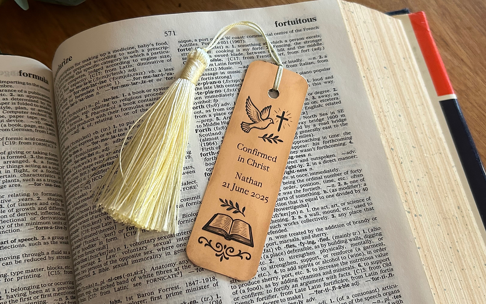 Thumbnail: Engraved Bronze Bookmark with a leather tie shown resting on a book